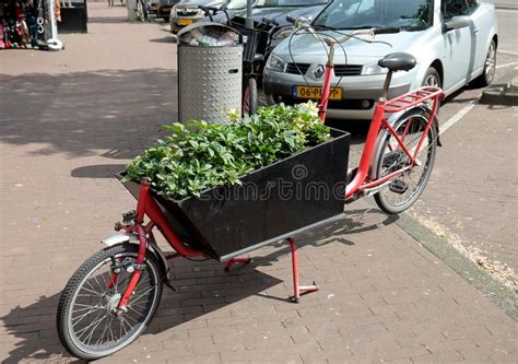 Een karretje getrokken door een fiets, geladen met bezittingen, symbolisch voor evacuatie.