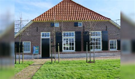 landschap met sloot en oude boerderijen in Opperdoes