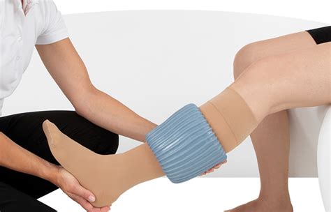 Klaslokaal met ziekenhuisbedden waar leerlingen oefenen met het aan- en uittrekken van steunkousen.