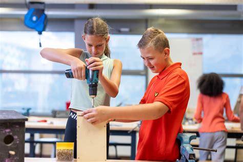 Leerlingen werken met gereedschap en machines in een technische werkplaats.