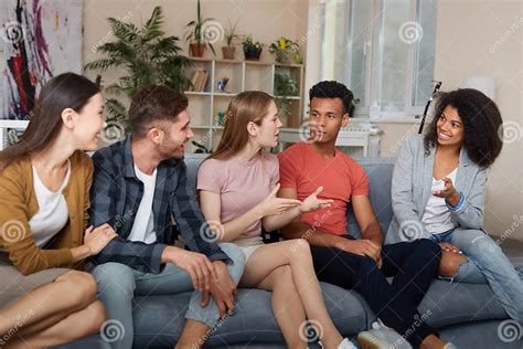 Foto van een diverse groep mensen die samen aan tafel zitten met koffie en thee