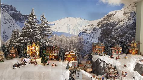 Een sfeervol verlicht dorpsplein tijdens Moergestel Kerstdorp, met de kerk op de achtergrond.