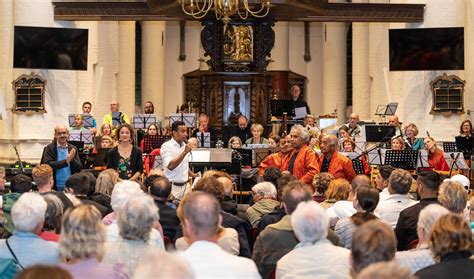 foto van een levendig meezingconcert met een enthousiast publiek