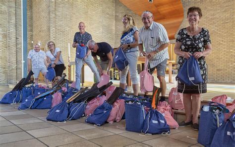 Foto van kinderen die blij een gevulde vakantietas ontvangen.