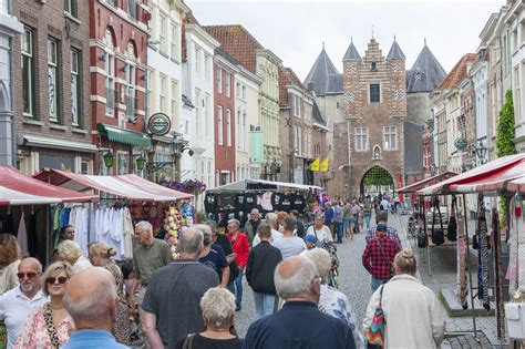Impressie van een drukke marktstraat tijdens een zomerfestival in Ouddorp