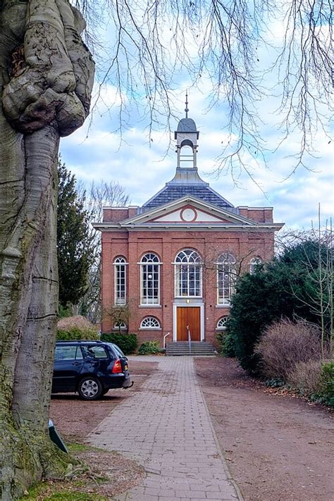 Vooraanzicht van de Doopsgezinde Kerk in Sappemeer met links de stam van de 18e-eeuwse Lohmanbeuk.