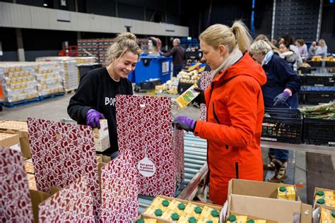 foto van een uitdeelpunt van de Voedselbank met vrijwilligers en wachtende mensen