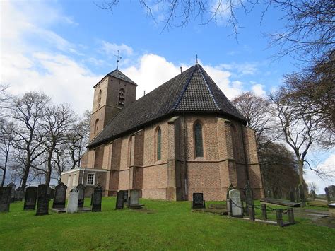 Landschapsfoto van de afgelegen kerk van Kolderveen, gelegen te midden van weilanden aan het einde van een laan.