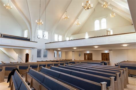 Interieur van het gerenoveerde kerkgebouw met flexibele stoelopstelling en moderne audiovisuele apparatuur