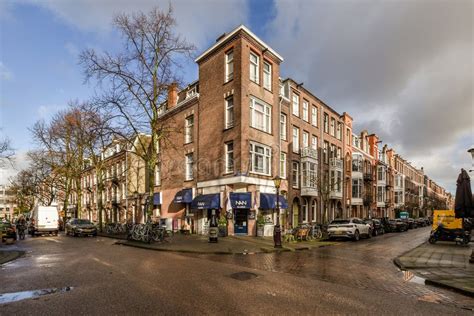 een straatbeeld in Rotterdam-Zuid met zowel woningen als winkels, met een hint van de stedelijke drukte