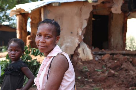 Heidi Baker die bidt voor een kind in Mozambique, beiden in een eenvoudige omgeving.