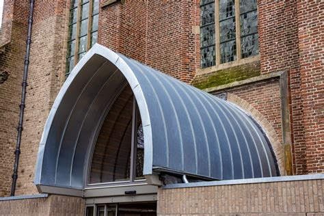 Architectonische details van de Hervormde Kerk van Grootegast, met nadruk op de rondboogvensters en de dakruiter.