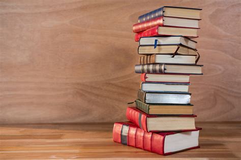 Een stapel boeken en een laptop die de behoefte aan vakliteratuur en permanente educatie symboliseren.