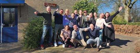 Een groep mensen die een kerkdienst bijwoont, met aandacht voor de sobere inrichting van het gebouw.