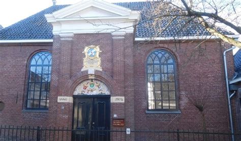 Gevelsteen van de Vermaning in Heerenveen met wapenschilden van de stichters