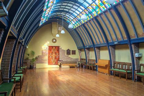 Interieurfoto van de Lutherzaal, met nadruk op de Amsterdamse School architectuur en glas-in-lood ramen.