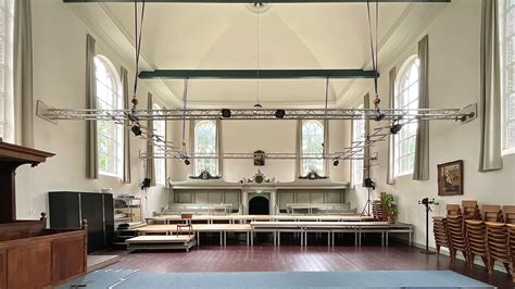 Ilustratieve foto van een kerkinterieur met een modern element, zoals een geluidsinstallatie of een projectiescherm