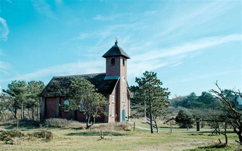 Foto van het Vredeskerkje in Bergen aan Zee, gelegen te midden van groen