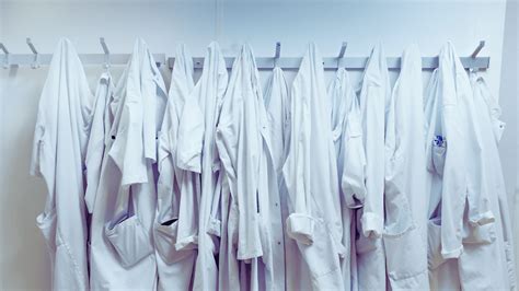 Wetenschappers in witte labjassen met spandoeken met wetenschappelijke grafieken en data tijdens een protest.