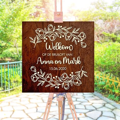 Een elegant welkomstbord met namen van het bruidspaar bij de kerkelijke ingang.