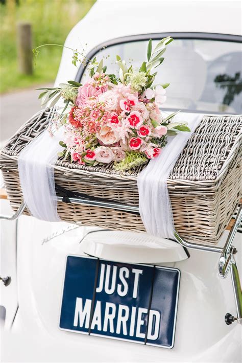 Trouwauto versierd met linten en een 'Just Married'-bord.