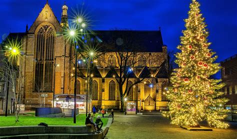 Artistieke weergave van een kerstnachtdienst in een kerk met kaarslicht en een kerstboom