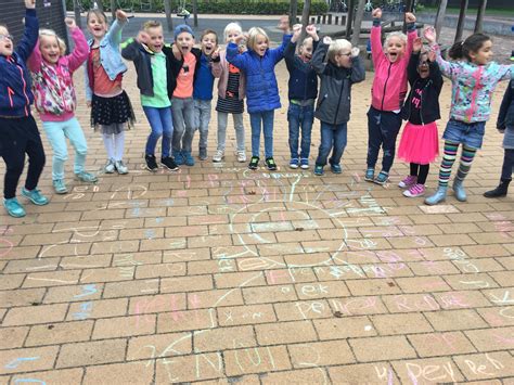 Foto van kinderen die deelnemen aan een kindernevendienst, met vrolijke gezichten en educatief materiaal.