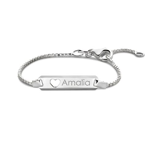 Een close-up van een zilveren plaat armband met een persoonlijke gravure, gericht op het detail van de inscriptie.