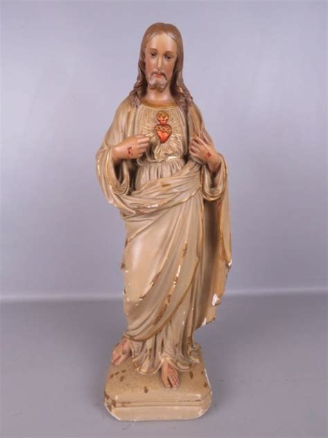 Een religieus beeldje dat de doop symboliseert, mogelijk een volwassene die gedoopt wordt.