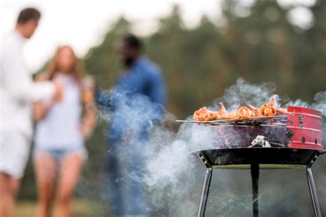 Een groep mensen geniet van een braai in de buitenlucht, typisch Zuid-Afrikaans