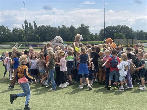 Een groep kinderen die actief deelneemt aan een les in de buitenlucht.