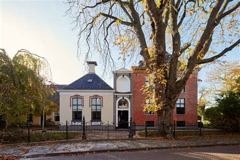 Een sfeervolle foto van de voormalige pastorie aan de Molendijk in Goudswaard, omringd door groen.