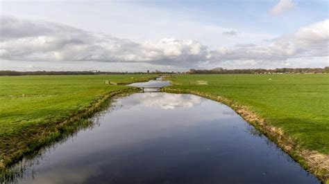Landschap van het veengebied rond De Krim met kanalen en sloten.