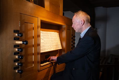 Foto van een predikant die orgel speelt tijdens een concert.