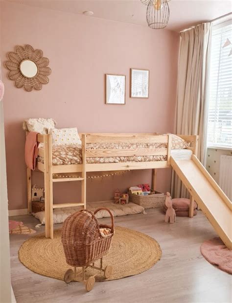 Een lege kinderkamer met een roze bed en een lege kast