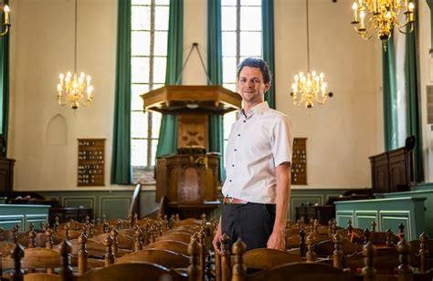 Nunspeet kerkgebouw met predikant in gesprek