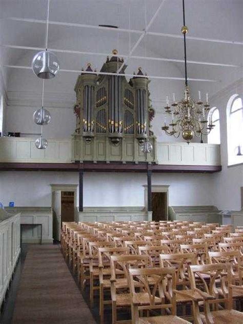 Interieur van een Doopsgezinde kerk, met focus op de preekstoel en orgelkraak.