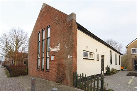 Foto van de Doopsgezinde kerk in Broek op Langedijk, met nadruk op de voorgevel en quiltkunst.