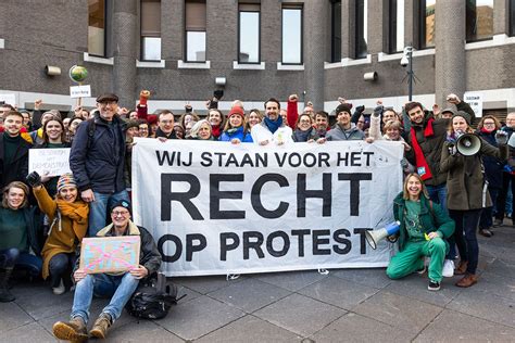Afbeelding van een demonstratie van Code Rood of Extinction Rebellion, met nadruk op de vreedzame aard van de protesten.