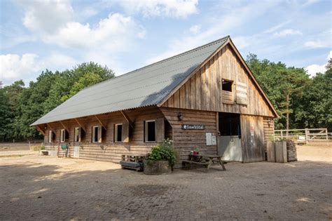 Foto van de stal van Krijn Vogelaar achter de boerderij waar de kinderen voor staan.