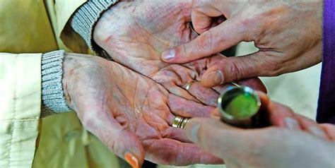 Afbeelding van een hand die olie aanbrengt op het voorhoofd van een persoon, symbool van ziekenzalving.