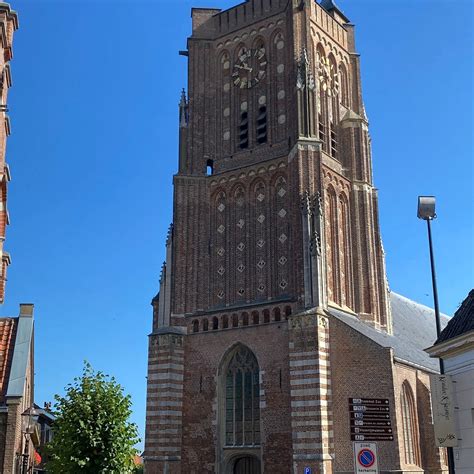 Gedetailleerde foto van de voorgevel van de Sint-Martinuskerk, met nadruk op de rondboogportaal en het Martinusbeeld.