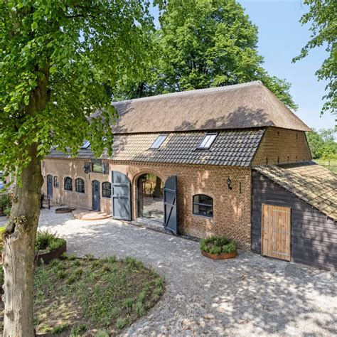 Oude boerderij in een duinlandschap