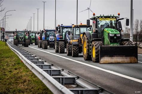Foto van boerenprotest bij een provinciehuis met trekkers en protestborden
