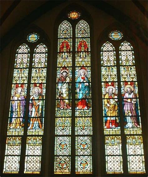 Architectonische details van de Sint-Rafaëlkerk, waaronder het glas-in-loodraam en de kruiswegstaties