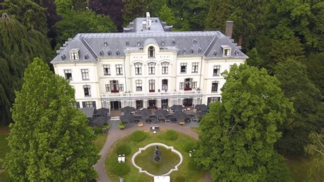 Gedetailleerde vooraanzicht van Villa Ruimzicht met de kenmerkende architectonische elementen zoals de veranda, dakkapellen en decoratieve elementen.