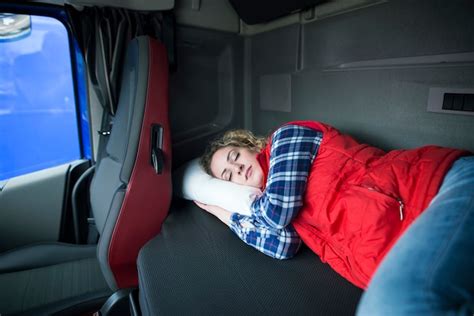 foto van een vrachtwagenchauffeur die in de cabine van zijn truck slaapt