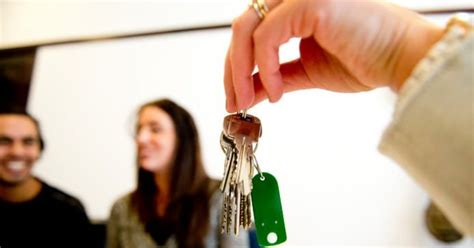 Illustratie van een predikant die een sleutel van een eigen woning ontvangt, met op de achtergrond een kerk.