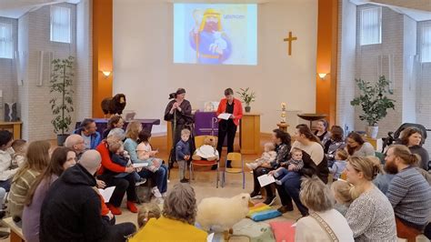 Groepsfoto van een kerkdienst met aandacht voor kinderen.