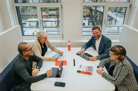 Foto van een werkgroep die aan tafel zit en plannen bespreekt.